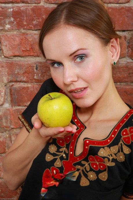Young girl Sabrina Moore holds a green apple before showing her trimmed vagina