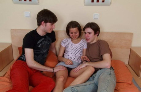 Petite teen July has sex with two boys at the same time on a bed