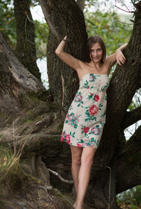 Young solo girl with perky tits gets completely naked beside a river