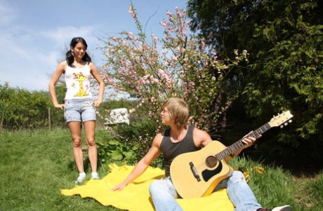 Young brunette has sex with a boy on a blanket after he serenades for