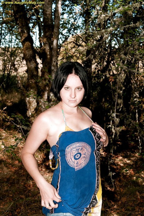 Busty brunette teen gets naked and touches herself in the forest.