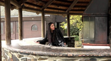 Dark haired girl pisses on the counter of an outdoor bar in an act of revenge