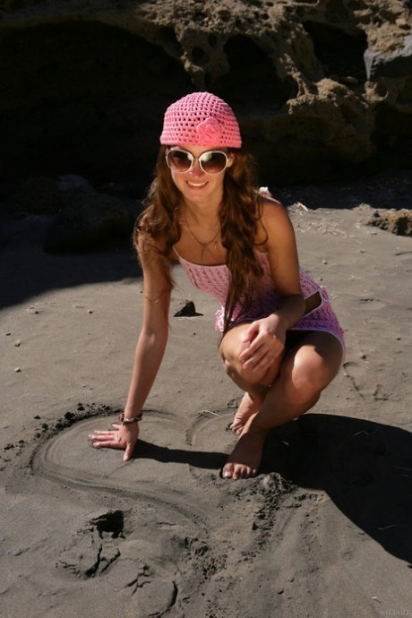 Barefoot girl gets naked while wearing a pink beanie and sunglasses