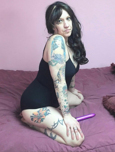 Tattooed fatty Lexxi Meyers toys her shaved pussy with a dildo on her bed