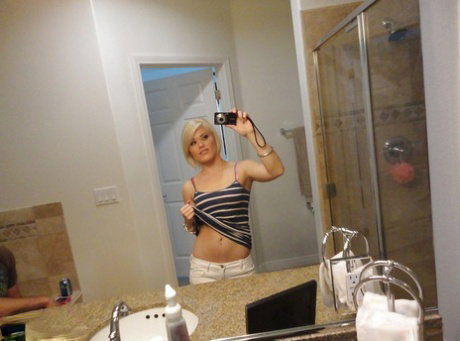 Young blonde hottie Ash Hollywood taking selfies in mirror while undressing