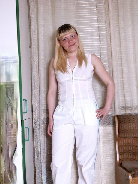 Blonde amateur with a tight ass removes white clothes to pose naked
