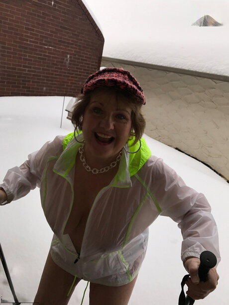 Mature lady Busty Bliss exposes her big tits while poleing in the snow