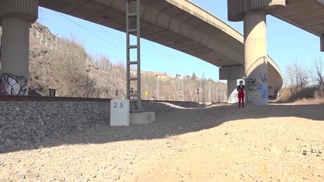 Brunette chick Olivia takes a piss beside railroad tracks under a bridge