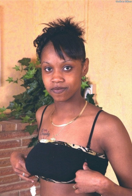 Black girl in a backless top shows her trimmed pussy prior to dildoing