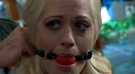 Naked blonde Holly Heart is masturbated in public while restrained