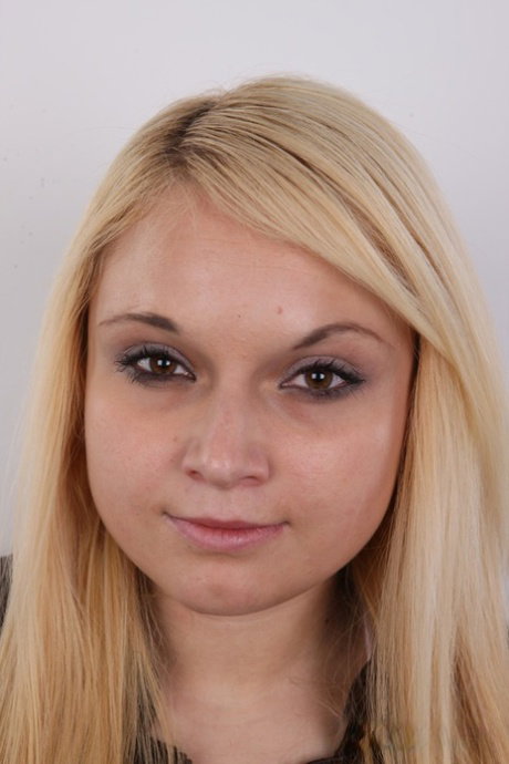Blonde girl with a big ass stands naked after stripping off her clothes