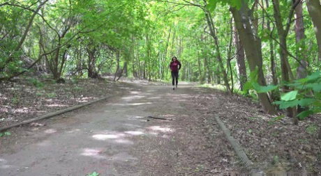 Barbe pulls down black leggings to pee on a roadway through the woods