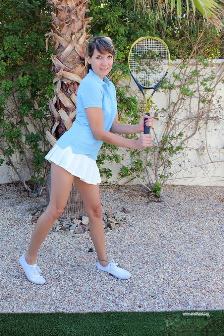 Teen girl Andi Land removes her upskirt panties while holding a tennis racket