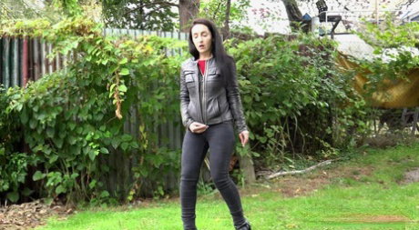 Long haired Corin bares her hairy pussy while taking a pee on the grass