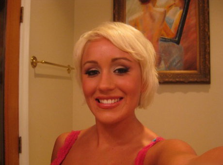 Short haired blonde Tristan Taylor undresses on bed to appease her boyfriend