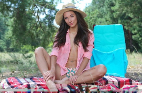 Young brunette Kenya poses in the nude while on a blanket in a field