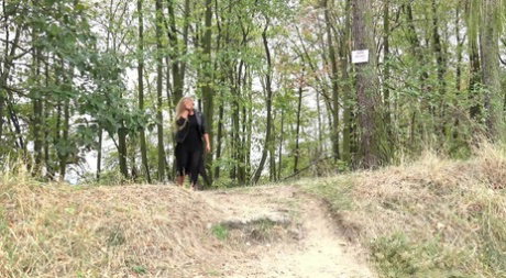 Blonde girl Jenna Lovely takes a piss while descending a bank near the woods