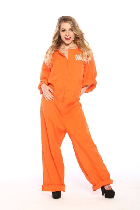 Female prisoner with dirty blonde hair releases her small boobs from jumpsuit