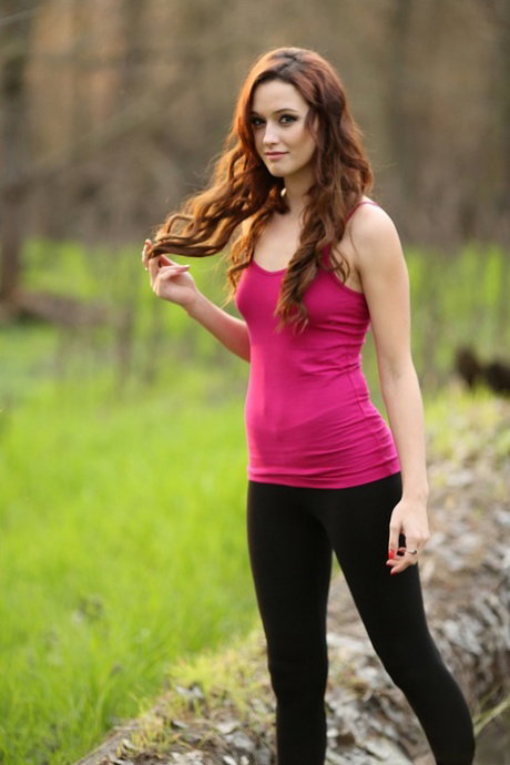 Redhead amateur Hayden Ryan slides legging over thong atop fallen tree