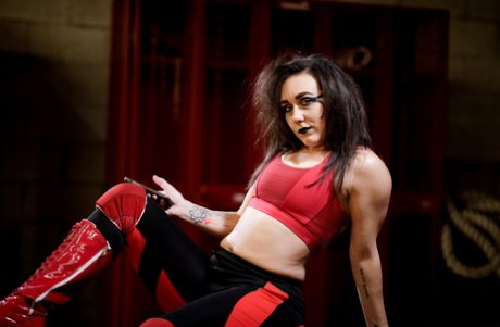 Brunette MILF Ariel X pulls down athletic wear on a bench in a locker room