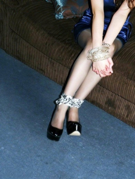Clothed girl Tamara is tied up at her wrists and ankles while on a couch