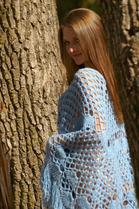 Thinwhite girl Olga L slips off her poncho to model naked amid fallen leaves