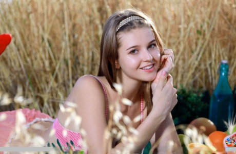 Adorable teen Libby gets naked while picnicking amid long grass