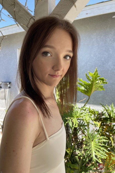 Fresh faced white slut exposes her long legs and sexy pussy on a bed
