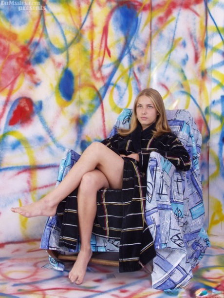 Pretty European teen Alina exposes her small breasts while resting on a chair