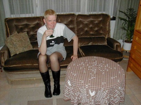 Mature blonde Tiffany Pearl gets naked on a sofa in stockings and black boots