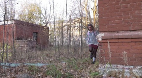 White girl Rita bares her bum while taking a piss by an abandoned building