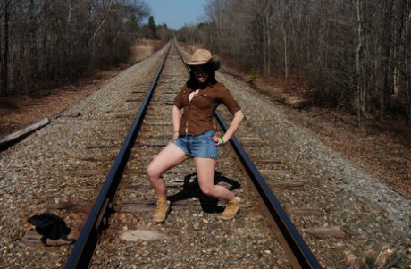 Young amateur Emily Love exposes herself on railway tracks in a hat and boots