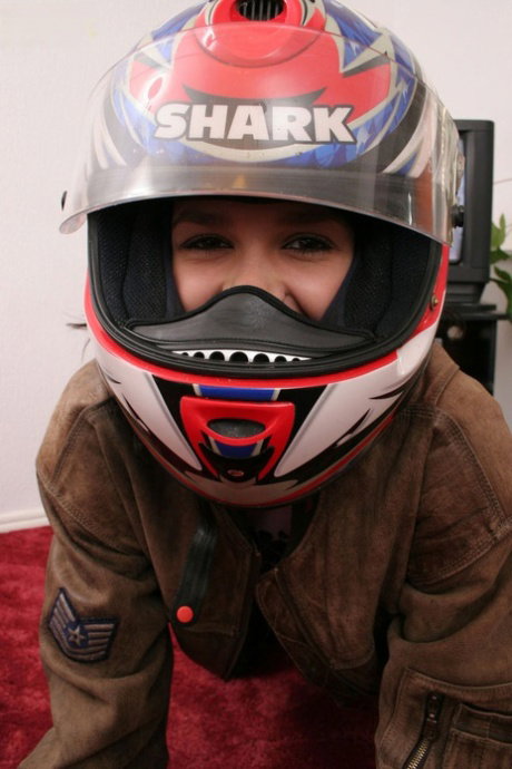 Cute teen sits dons her motorcycle helmet during her first nude poses