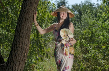 Charming teen Black Mo gets totally naked against the crook of a tree