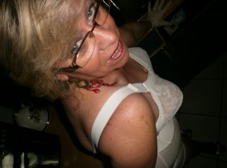 Mature blonde Caro exposes her hairy pussy while in her kitchen