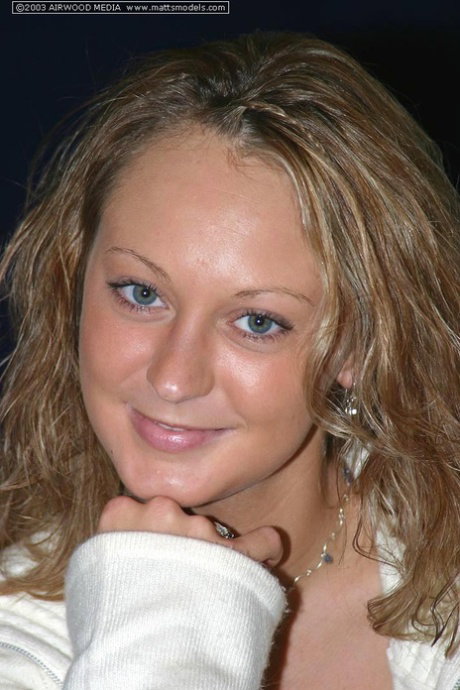 Blond amateur Danny undresses before showing her landing strip pussy on a bed