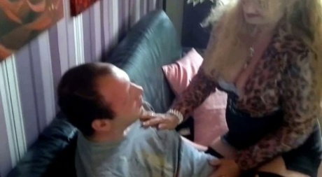 Older woman gets naked before blowing her man's cock on a leather couch