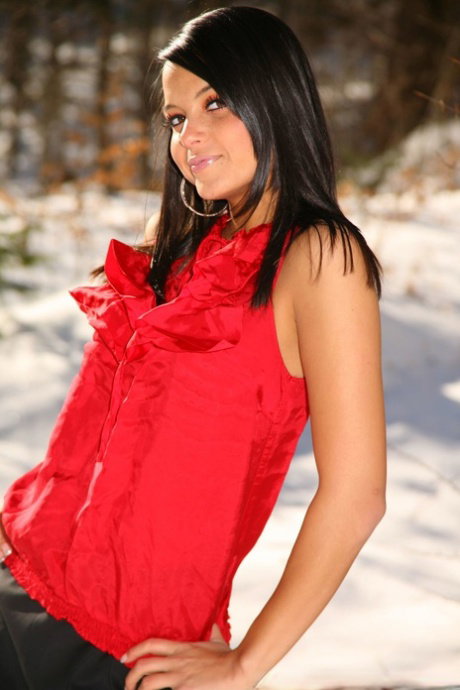 Black haired vixen Bebe showcases her tiny tits and poses in nylons on snow