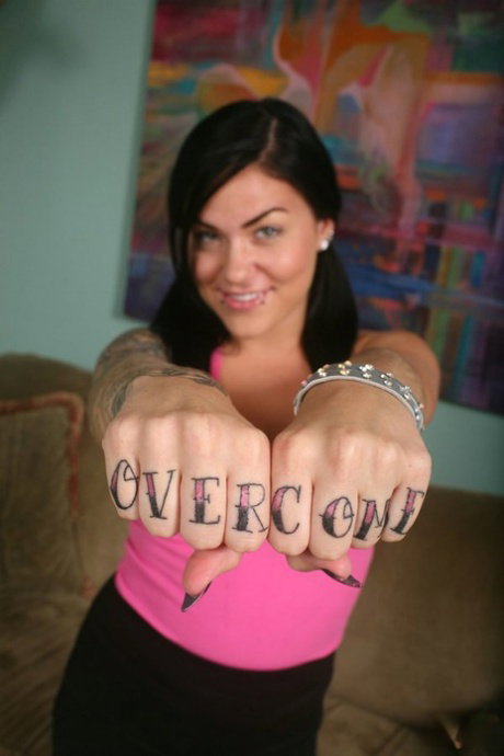 Tattooed brunette Karmen Karma disrobes prior to giving a POV handjob