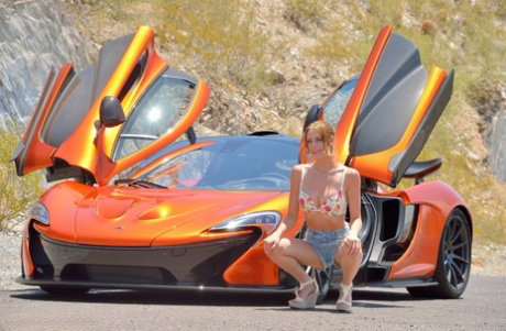 Slim solo girl stretches out her pink pussy after modeling by a sports car