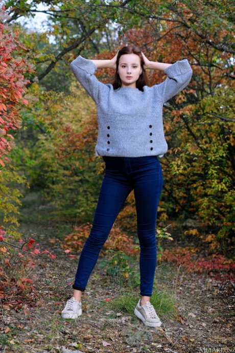 Beautiful teen girl strikes tempting nude poses on blanket in the woods