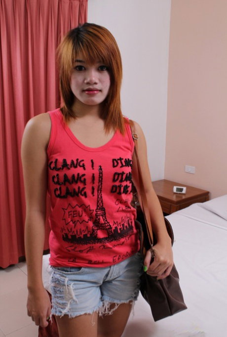 Cute Thai teen Oam strips in a hotel room and flashes her tits and hairy cunt