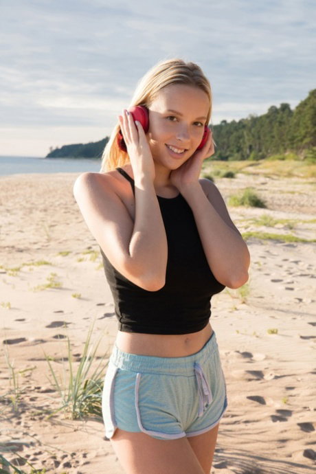 Busty babe Agatha flaunts her juicy tits and her shaved pussy at the beach