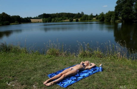 Thin blonde teen Kiara Cole doffs a bikini before toying her pussy near water