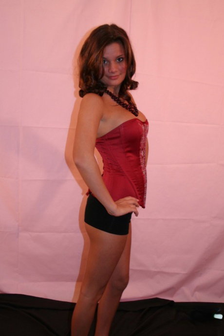 Cute teen Kate Crush takes off a bustier before covering up her naked breasts