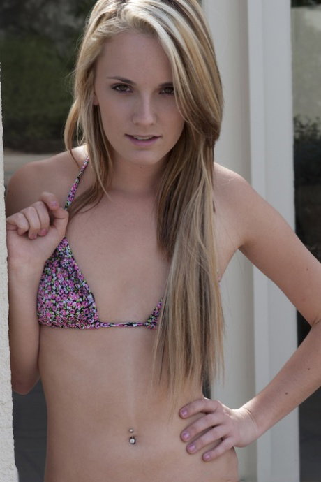 Young blonde Sara James plays with her hair after getting naked on a veranda