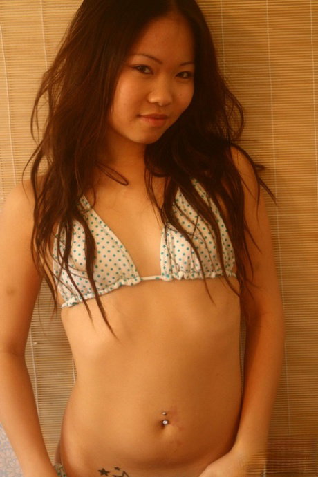 Adorable Asian teen Grace undoes her bikini top in a teasing manner