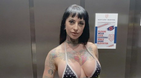 Inked slut Jessie Lee deepthroats a dick and strokes it with her big tits