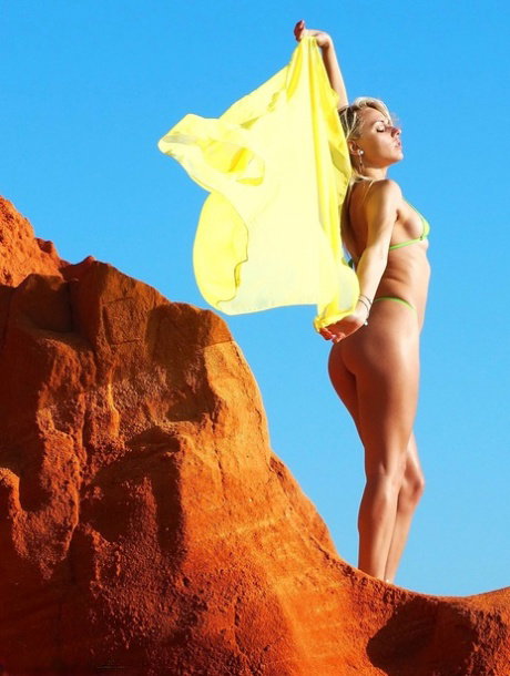Blonde solo girl Chloe Toy wades into the surf wearing a thong bikini