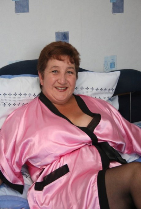 Mature fatty Kinky Carol looses her huge breasts from a satin robe and bra